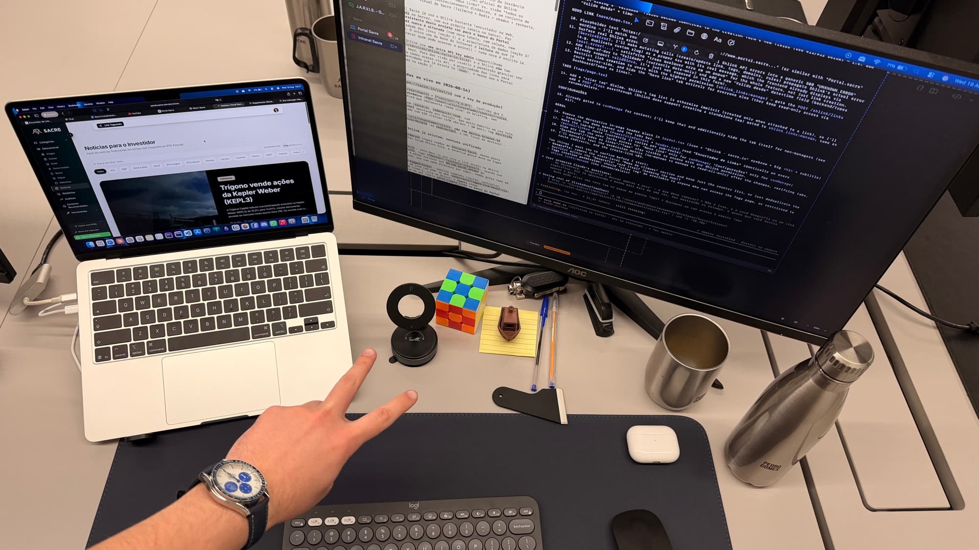 Pedro's desk at the company, code on the external monitor and a Rubik's cube beside the keyboard