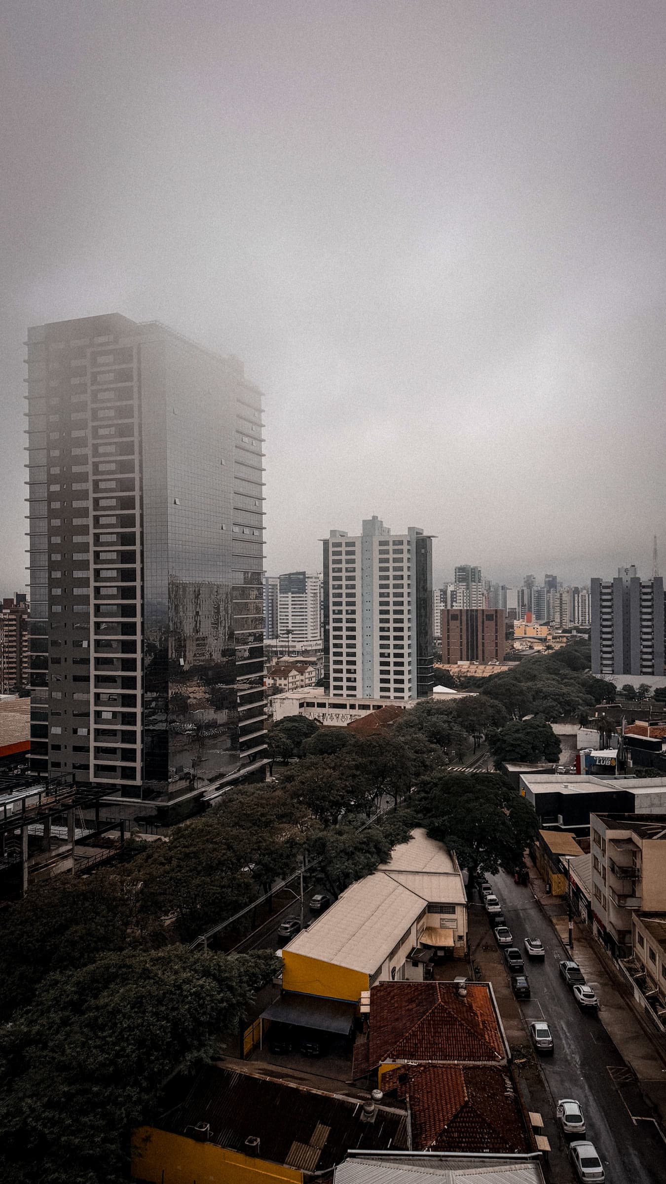 Maringá skyline beneath a gray rainy sky