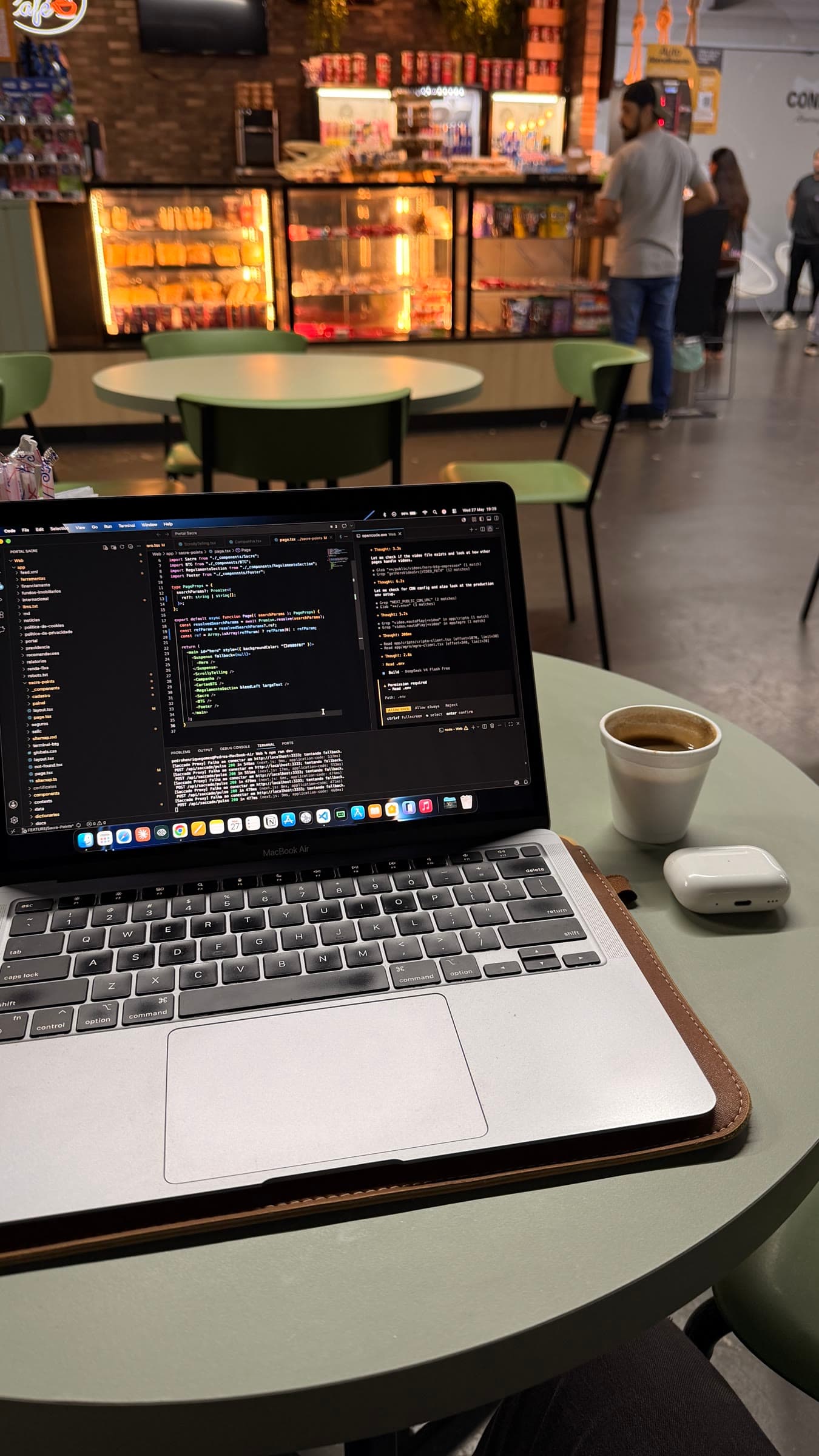 MacBook showing source code on a café table