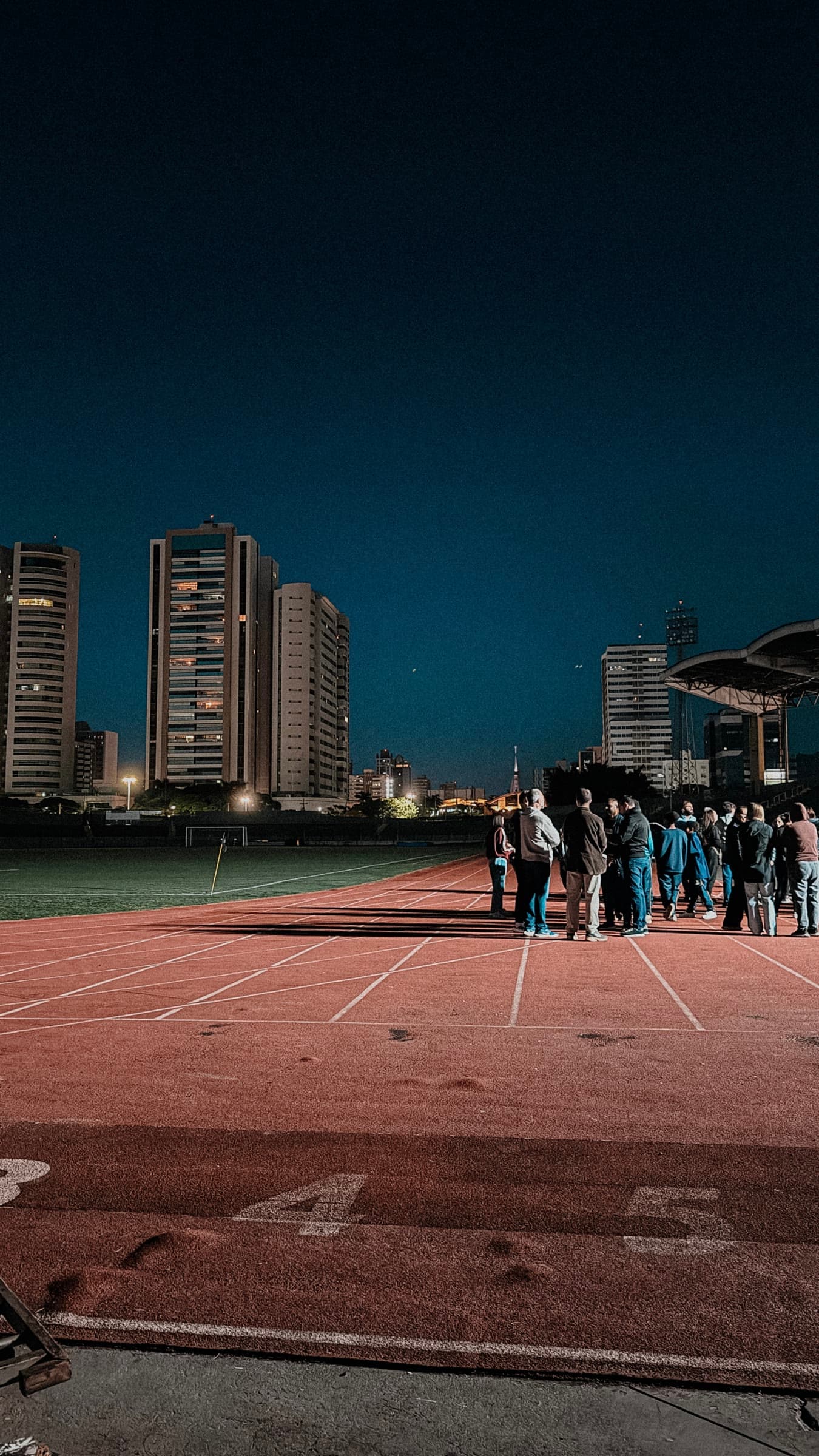 Athletics track and city buildings at night